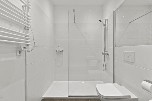 a white bathroom with a shower and a toilet at 4 Min to Metro I 12 Min to Inner City I Top Wifi in Vienna