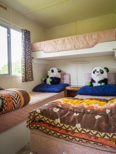 2 pandas farcis sont assis sur des chaises dans une chambre dans l'établissement Mobile Home auf Campingplatz mit Naturbadesee, à Parsac