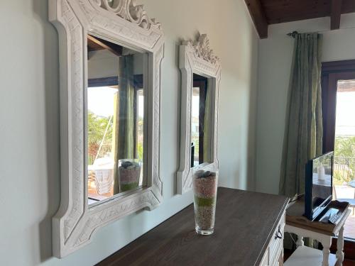 a vase sitting on a table in front of two mirrors at Villa Camilla-Stintino, Sardegna in Sassari