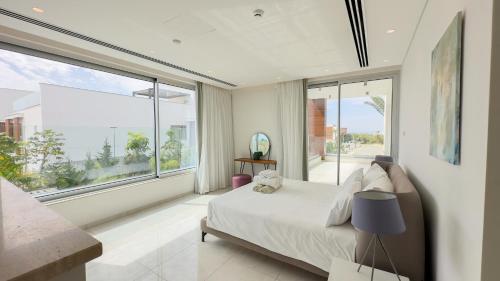 a bedroom with a bed and a large window at Vivo Mare Beachfront Villas - Vista in Ayia Napa