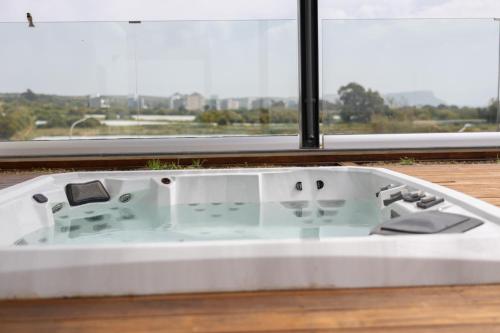 a white bath tub with a view of a window at Vivo Mare Beachfront Villas - Vista in Ayia Napa