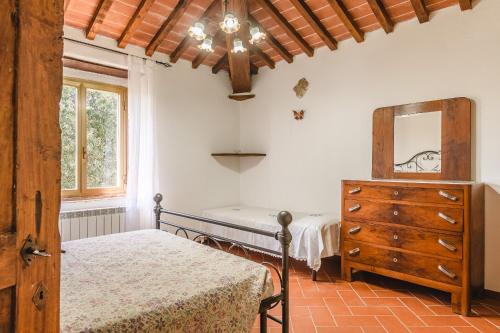 a bedroom with a bed and a dresser and a window at Villa Lo Stemma in Monte San Savino