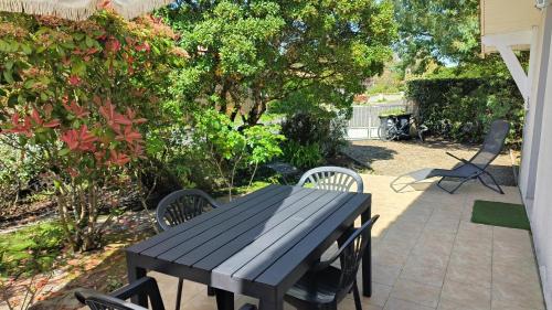 une table noire et des chaises sur une terrasse dans l'établissement Maison 