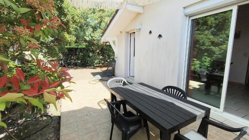 une table noire et des chaises sur une terrasse dans l'établissement Maison 