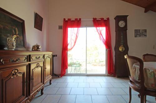 Cette chambre dispose d'une commode et d'une fenêtre avec des rideaux rouges. dans l'établissement Maison 