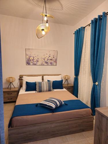 a bedroom with a large bed with blue curtains at Dimitra's house in Glóssa