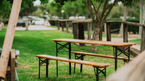 two benches sitting in the grass in a park at TAIGA Tarifa Valdevaqueros in Tarifa