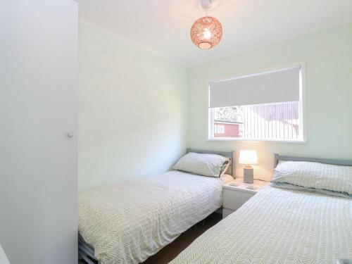 Un dormitorio con dos camas y una ventana. en Number 19, en Cromer