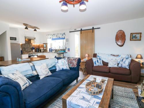 a living room with blue couches and a table at Periwinkle Cottage in Banff