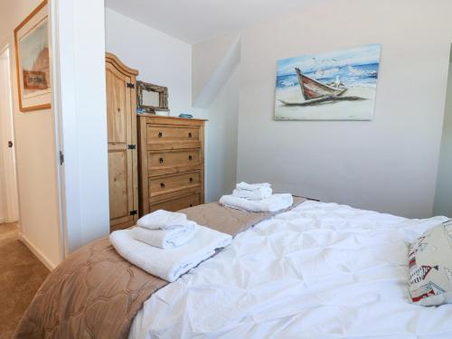 a bedroom with a bed with towels on it at Periwinkle Cottage in Banff