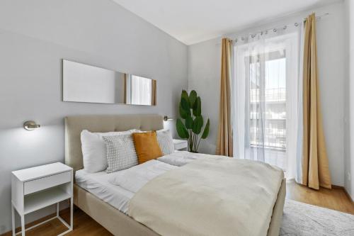 a white bedroom with a bed and a window at 4 Min to Metro I 12 Min to Inner City I Top Wifi in Vienna