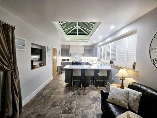 a kitchen and living room with a couch and a table at Holly Cottage in Hutton le Hole