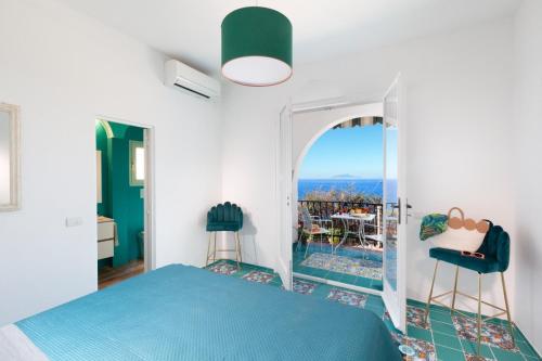 a bedroom with a blue bed and a balcony at Estate4home - Suite Bonview in Massa Lubrense