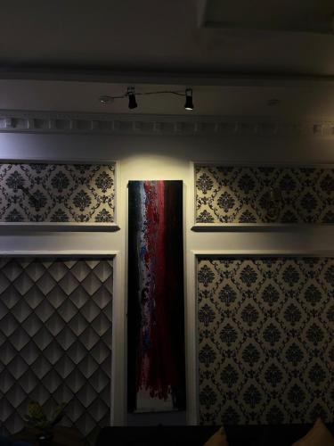 a room with two doors and a wall with wallpaper at Luxury Cozy 3BR Home near airport, DHA Phase 9 Town Lahore in Lahore