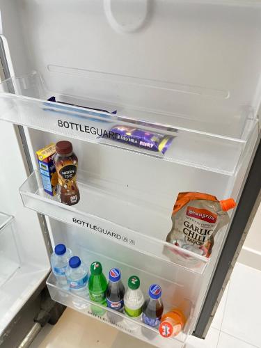 an open refrigerator filled with lots of food and drinks at Luxury Cozy 3BR Home near airport, DHA Phase 9 Town Lahore in Lahore