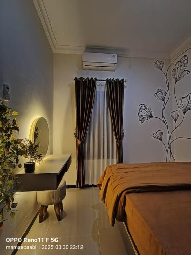 a bedroom with a bed and a desk and a window at CABI'N Homestay in Jarakan