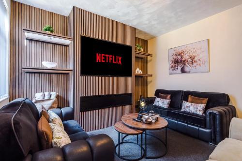 a living room with a couch and a tv at Cosy 3BR Family Home Near Etihad and Coop Live - Free Parking! in Manchester