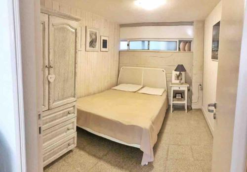 a small bedroom with a bed and a dresser at Heraklion-Pinelopi Apartment in Ayía Marína