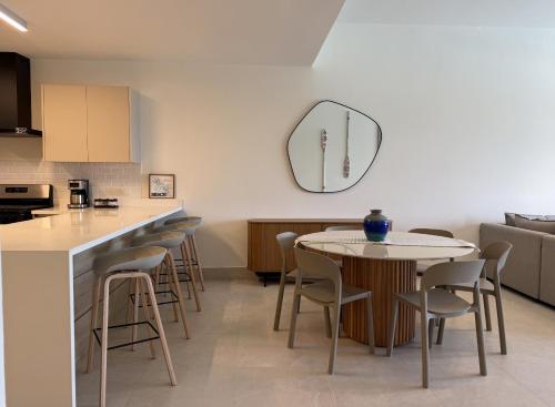a kitchen with a table and chairs and a mirror at AmazINN Places Playa Escondida in María Chiquita