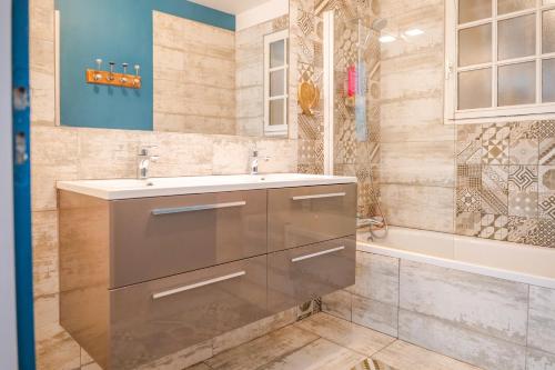 a bathroom with a sink and a tub at magnifique villa avec piscine - 8 personnes - paracou in La Chaume