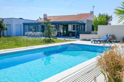une piscine devant une maison dans l'établissement magnifique villa avec piscine - 8 personnes - paracou, à Les Sables-dʼOlonne