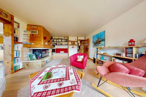 un salon avec une table, des chaises et des étagères dans l'établissement La Fruitière pour des vacances réussies, à Seynod