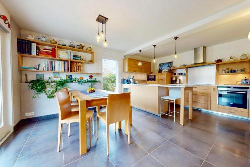 une cuisine avec une table et des chaises en bois dans l'établissement La Fruitière pour des vacances réussies, à Seynod