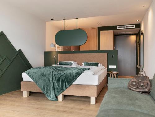 a bedroom with a large bed with a green blanket at Pension Höfler - Fernblick in Schenna