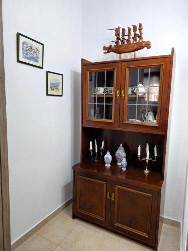 a large wooden cabinet with candles in a room at Dimitra's house in Glóssa