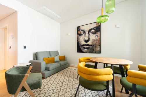 a living room with a couch and a table and chairs at Baía Terraza Cascais Apartment in Cascais