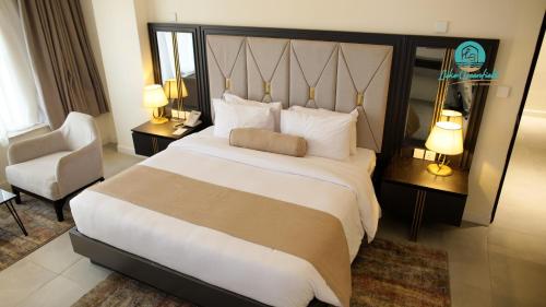 a hotel room with a large bed and a chair at Lake Greenfield Hotel and Towers in Abuja