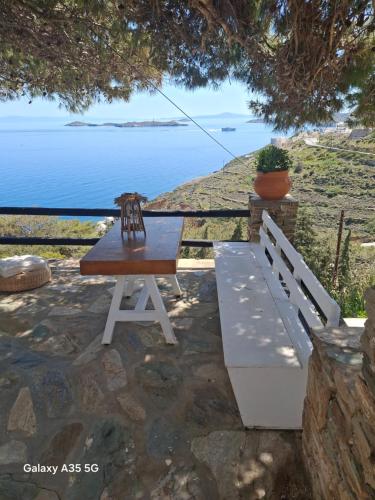 a picnic table and a bench with a view of the ocean at Thealos view in Ermoupoli