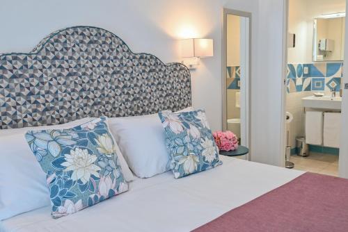 a bedroom with a bed with a large headboard and pillows at La Dimora di Nonna Maria in Maiori