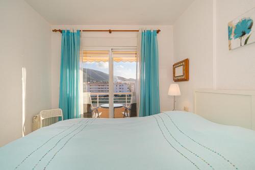a bedroom with a large bed and a window at Alborada Golf 13C in L’Alfàs del Pi