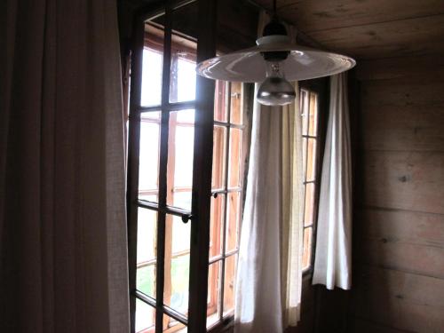 a window with a white curtain and a light at kulturland Retreat in Diemtigen