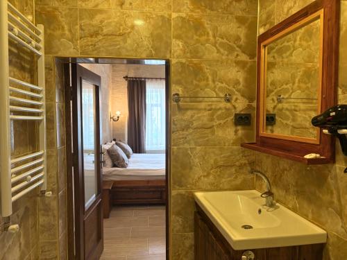 a bathroom with a sink and a mirror and a bed at Elysee Cave House in Goreme