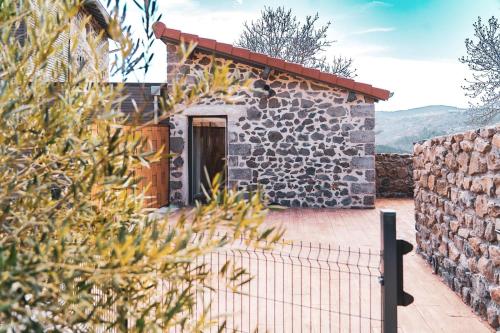 une maison en pierre avec une clôture devant elle dans l'établissement Le gite de la Bille, à Coubon