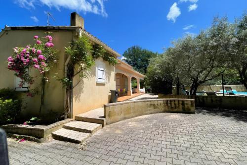 une maison avec une passerelle en briques à côté d'un bâtiment dans l'établissement Les Oliviers - Villa 10 people - 5 min Ardèche, à Saint-Julien-de-Peyrolas