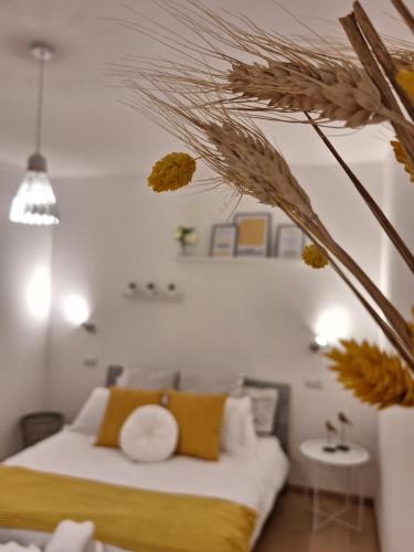 a bedroom with a bed with yellow and white pillows at Elunà Assisi Home in Assisi