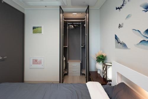 a bedroom with a bed and a walk in shower at Gwangan antique summer accommodations the ocean in Busan