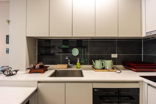 a kitchen with white cabinets and a sink at Gwangan antique summer accommodations the ocean in Busan