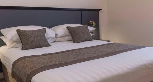 een groot bed met twee kussens erop bij Best Western Corona Hotel in Londen