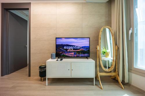a living room with a tv and a mirror at Gwangan antique summer accommodations the ocean in Busan