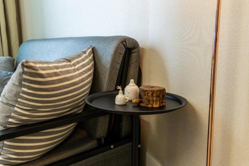 a table next to a chair with a pillow at Gwangan antique summer accommodations the ocean in Busan