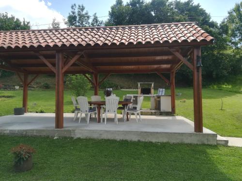 a wooden gazebo with a table and chairs at La belle campagne in Granges-dʼAns