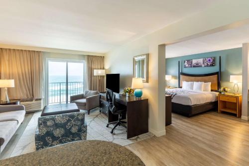 a hotel room with a bed and a desk at Sleep Inn on the Beach in Orange Beach