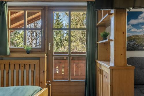 a bedroom with a large window and a bed at Pension Sonnenwinkl in Oberlängenfeld