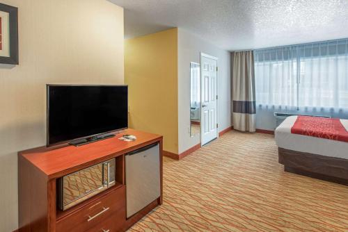 a hotel room with a bed and a flat screen tv at Comfort Inn Mount Shasta Area in Weed