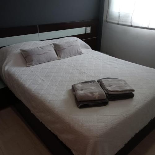 a bed with two pillows and two bags on it at Apartamento Castellet1 in San Vicente de Castellet