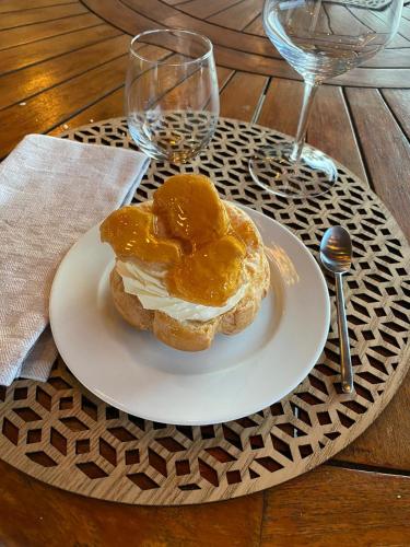 a white plate with a sandwich on a table with wine glasses at La belle campagne in Granges-dʼAns